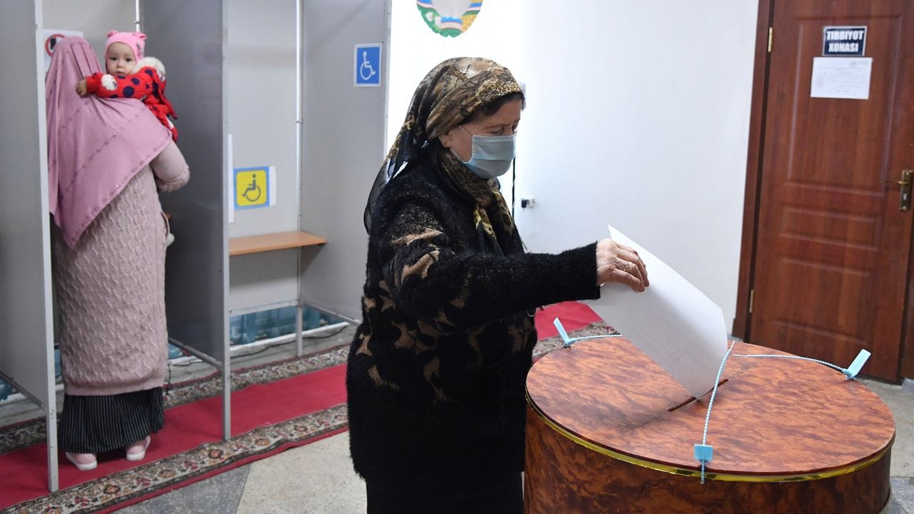 Eine Frau gibt in einem Wahllokal in Taschkent ihre Stimme ab.