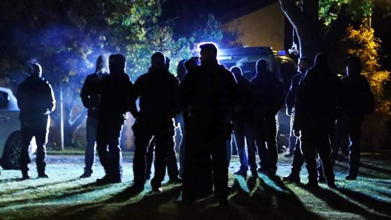 Polizisten stehen um dunkel gekleidete Rechte auf einer Wiese in Groß Gastrose: In der deutsch-polnischen Grenzregion wurde dazu aufgerufen, Flüchtlinge aufzugreifen.