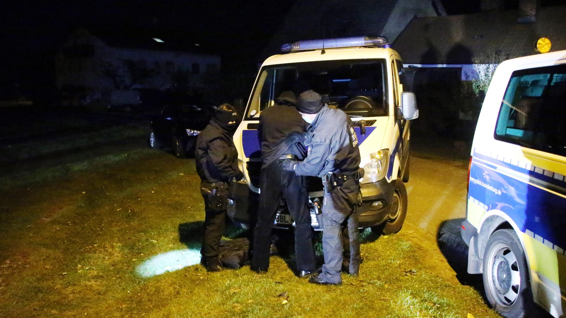 Polizisten durchsuchen vermummte Teilnehmer des "Grenzgangs": Bei den Einsätzen am Wochenende wurden mehrere Waffen gefunden.