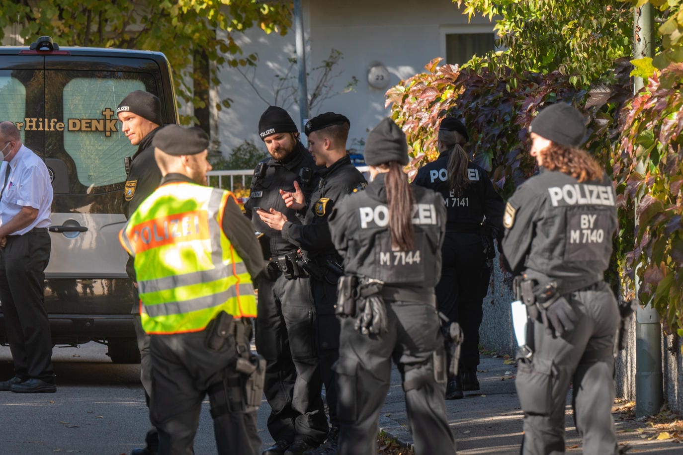 Polizisten und ein Bestatter stehen vor dem Tatort in München, wo eine 14-Jährige tot aufgefunden worden ist: Ein 17-Jähriger gilt als Tatverdächtiger.