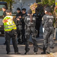 Polizisten und ein Bestatter stehen vor dem Tatort in München, wo eine 14-Jährige tot aufgefunden worden ist: Ein 17-Jähriger gilt als Tatverdächtiger.