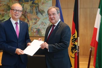 Der Präsidenten des nordrhein-westfälischen Landtags, André Kuper (l), überreicht Armin Laschet seine Urkunde über die Beendigung des Amtes als Ministerpräsident.