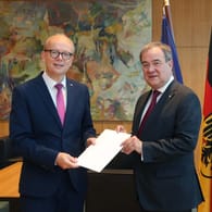 Der Präsidenten des nordrhein-westfälischen Landtags, André Kuper (l), überreicht Armin Laschet seine Urkunde über die Beendigung des Amtes als Ministerpräsident.