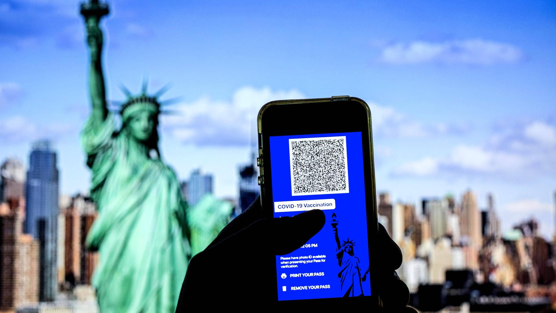 Digitaler Impfpass vor der Freiheitsstatue (Symbolbild): Einreisen in die USA sind ab November nach einer anerkannten Corona-Impfung wieder möglich.