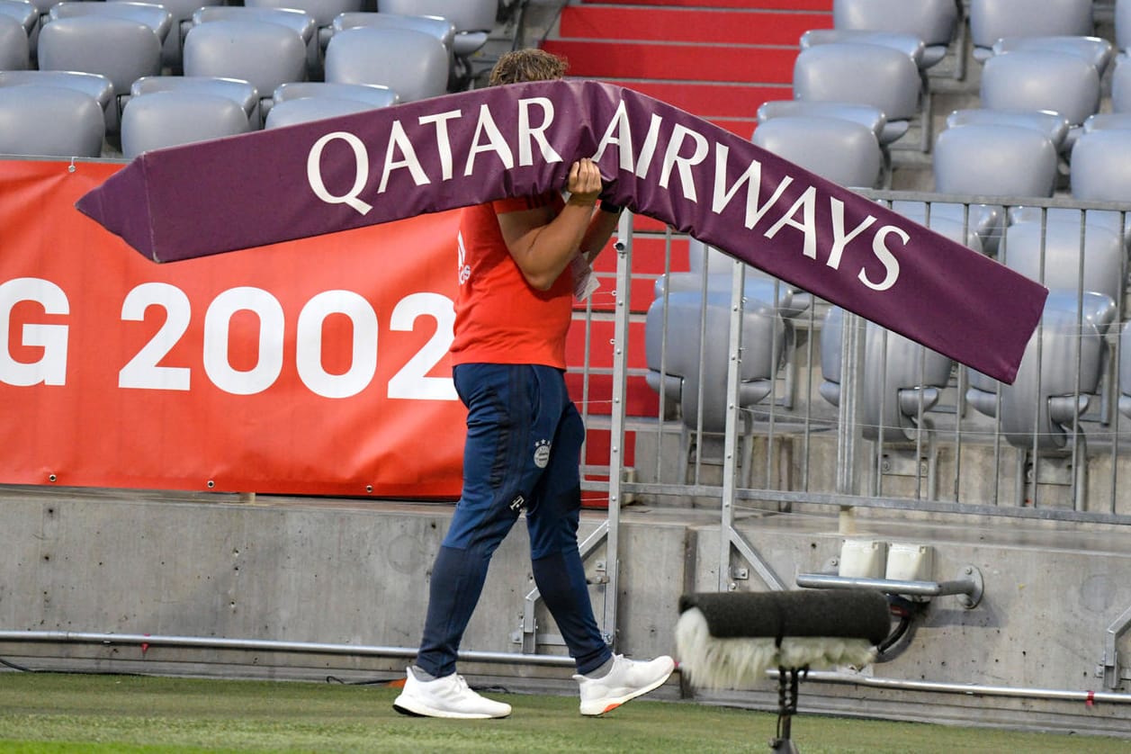 Ein Werbe-Aufsteller von Sponsor Qatar Airways wird aus der Allianz Arena getragen. Bayern-Fans wünschen sich eine Beendigung der Kooperation mit der arabischen Fluggesellschaft.