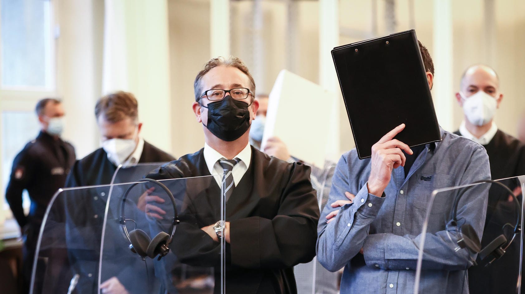 Die Angeklagten, ihre Anwälte und weitere Prozessbeteiligte stehen zu Beginn eines Prozesses im Gerichtssaal im Strafjustizgebäude. Vor dem Landgericht in Hamburg sind elf Männer wegen bandenmäßigem Kokain-Schmuggels angeklagt. Die Angeklagten, ihre Anwälte und weitere Prozessbeteiligte stehen zu Beginn eines Prozesses im Gerichtssaal im Strafjustizgebäude. Vor dem Landgericht in Hamburg sind elf Männer wegen bandenmäßigem Kokain-Schmuggels angeklagt.