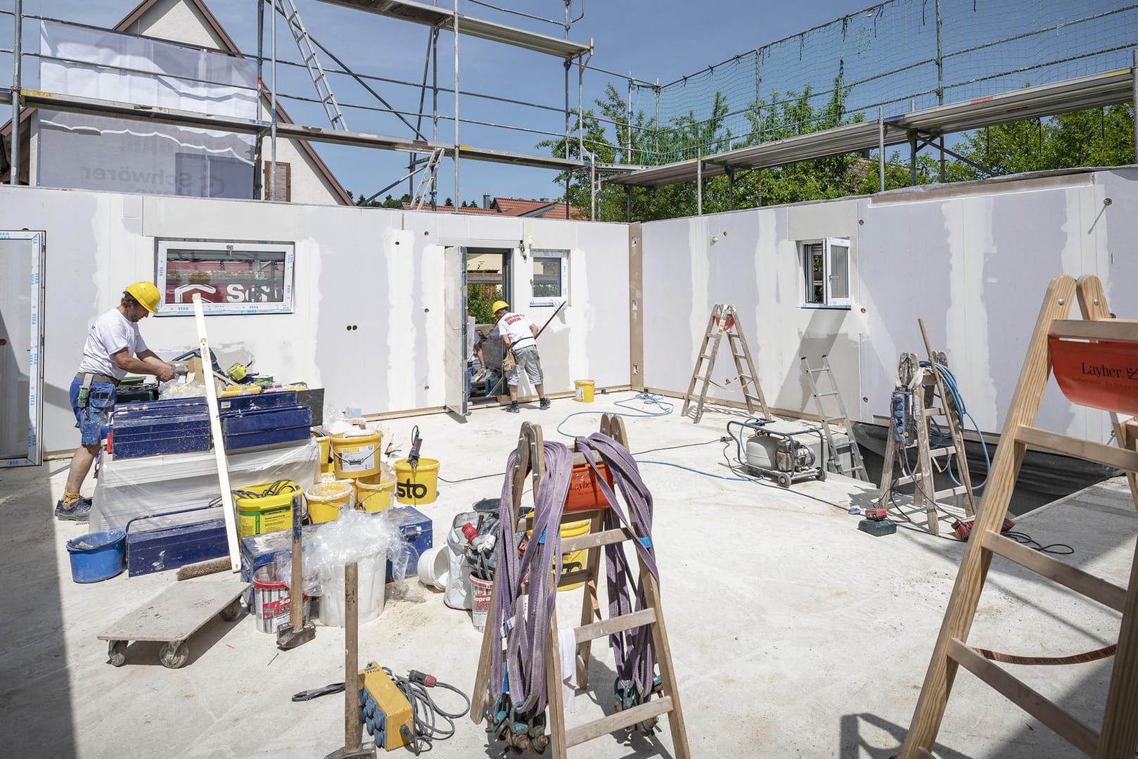 Handwerker bauen ein Haus (Symbolbild): Kommen auf der Baustelle Menschen zu Schaden, springt die Bauherrenhaftpflichtversicherung ein.