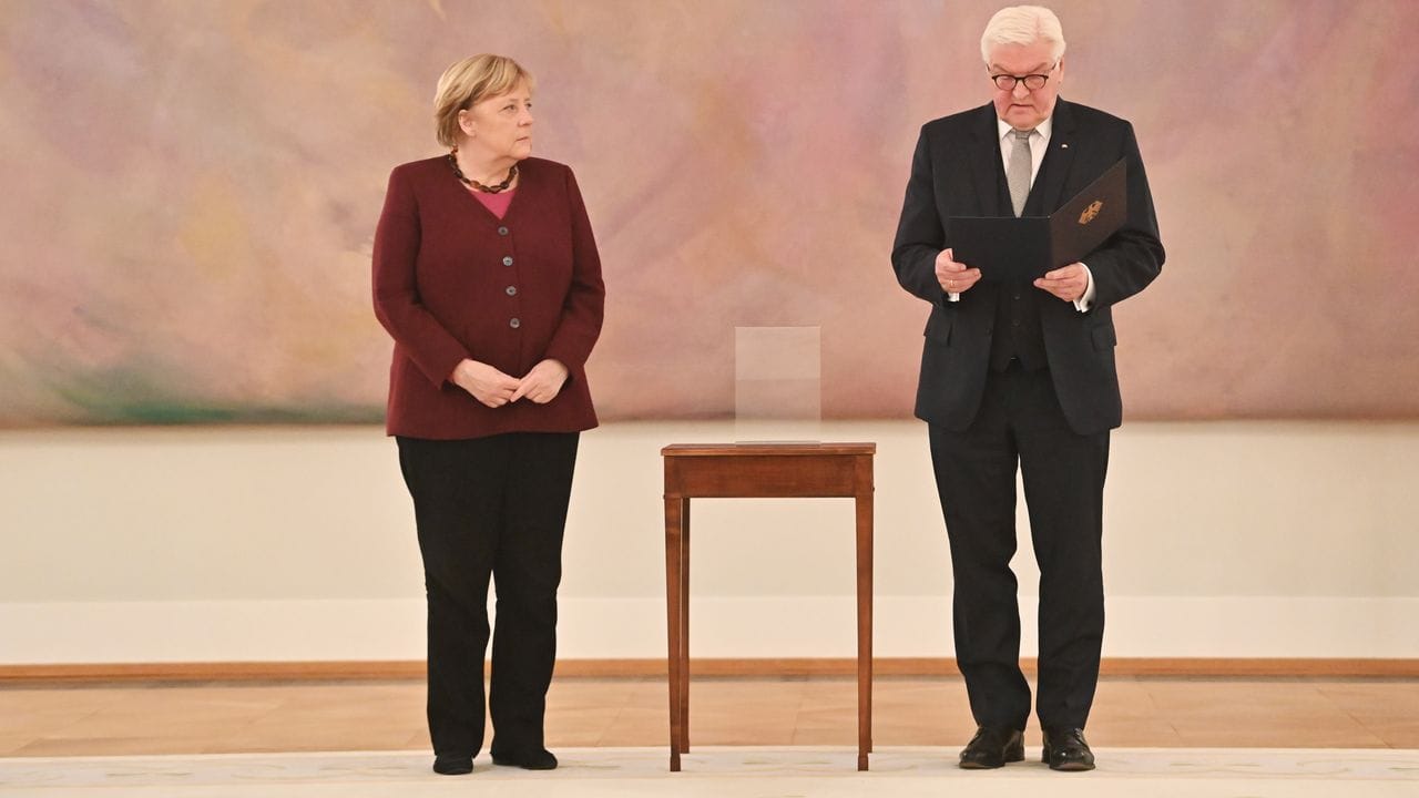 Bundespräsident Frank-Walter Steinmeier händigt Bundeskanzlerin Angela Merkel (CDU) die Entlassungsurkunde aus.