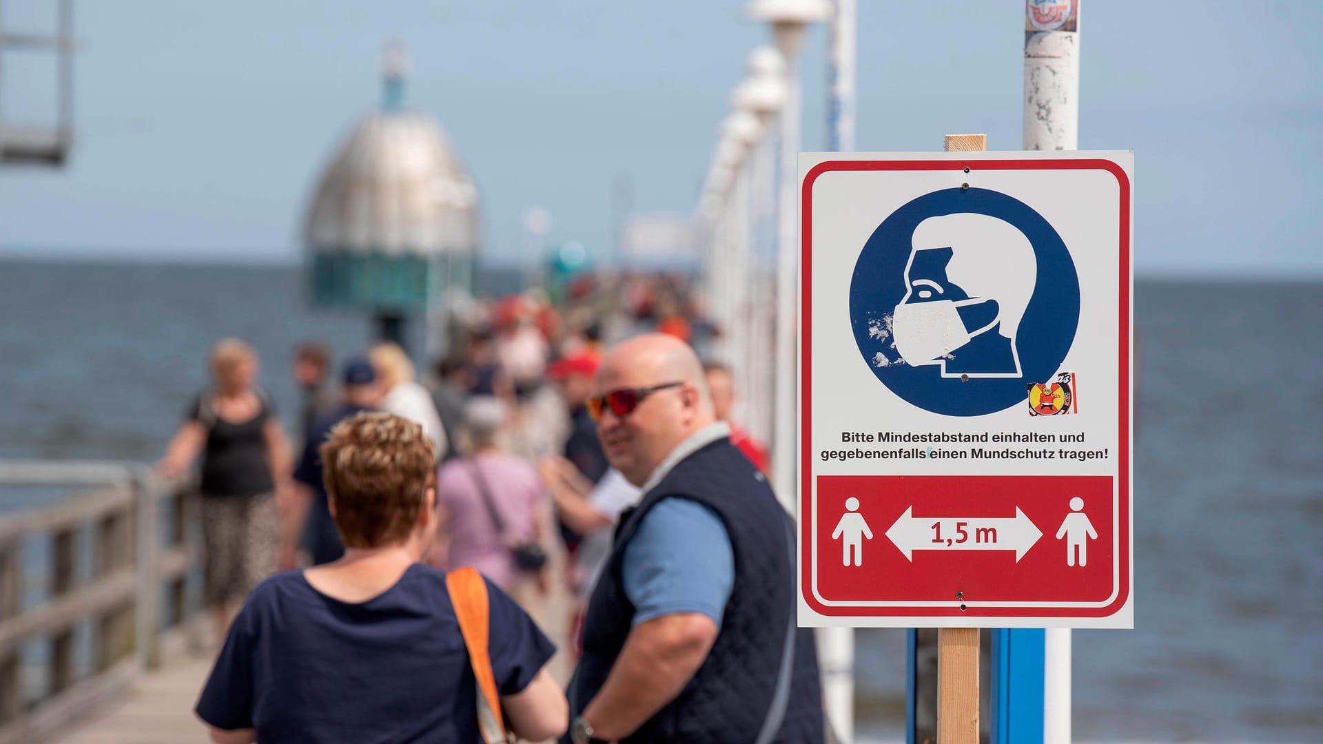 Ein Hinweisschild zur Einhaltung der Maskenpflicht und des Mindestabstands an der Seebrücke in Zinnowitz auf der Insel Usedom: Die Fallzahlen in Deutschland steigen nach dem Sommer weiter.