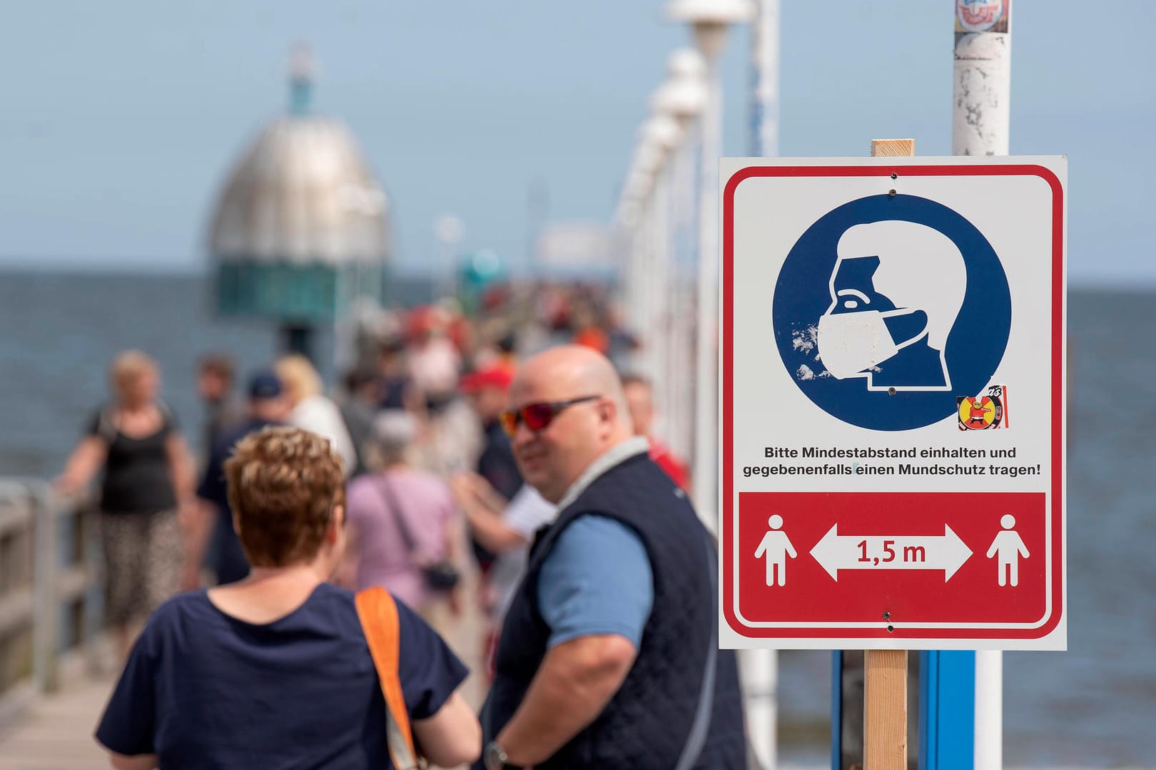 Ein Hinweisschild zur Einhaltung der Maskenpflicht und des Mindestabstands an der Seebrücke in Zinnowitz auf der Insel Usedom: Die Fallzahlen in Deutschland steigen nach dem Sommer weiter.