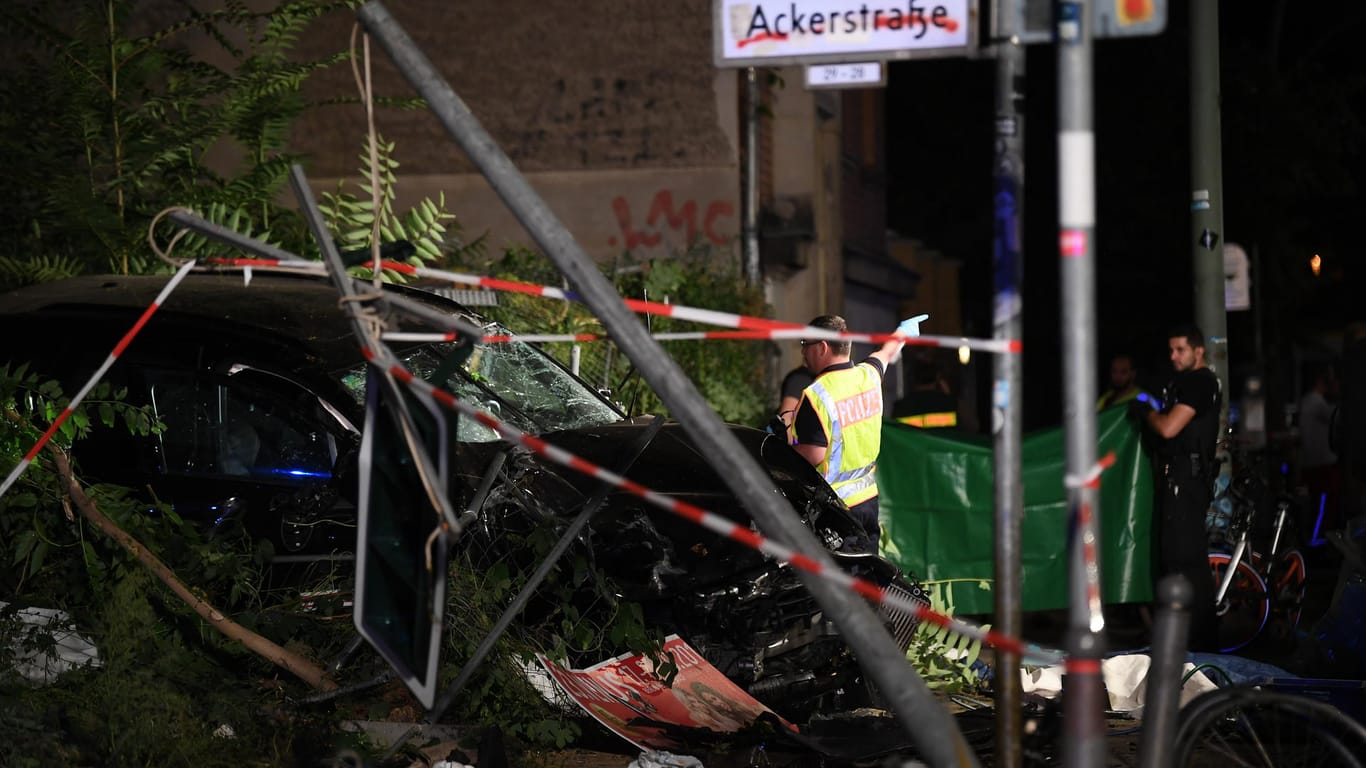 An einem zerstörten Auto halten Polizisten ein Plane (Archivbild): Das Auto war im Herbst 2019 an der Ecke Invalidenstraße/Ackerstraße auf einen Gehweg gefahren.