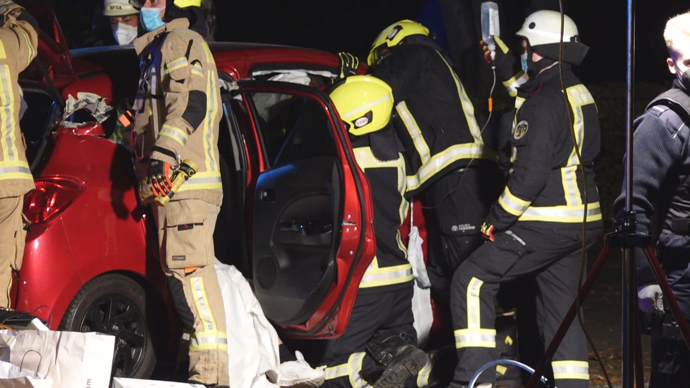 Einsatz in der Nacht: Während im Auto Verletzte versorgt werden, schneiden andere Feuerwehrleute das Dach ab.