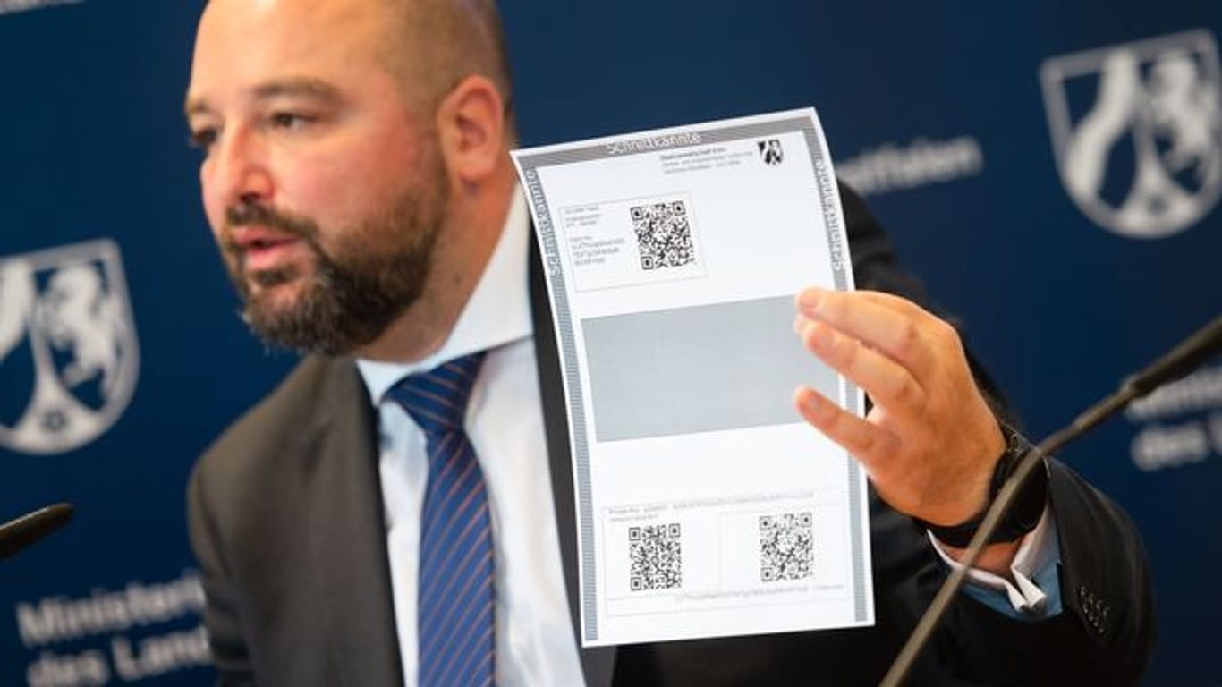 Andreas Brück von der Ansprechstelle Cybercrime NRW zeigt während einer Pressekonferenz ein Paper Wallet für Bitcoin: Wenn alle digitalen Münzen einen so hohen Wert erzielen, erzielt das Land damit einen zweistelligen Millionenbetrag.
