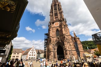 Menschen stehen auf dem Freiburger Münsterplatz: Die Stadt im Südwesten des Landes erfreut sich sowohl bei Touristen wie auch bei Einheimischen großer Beliebtheit.