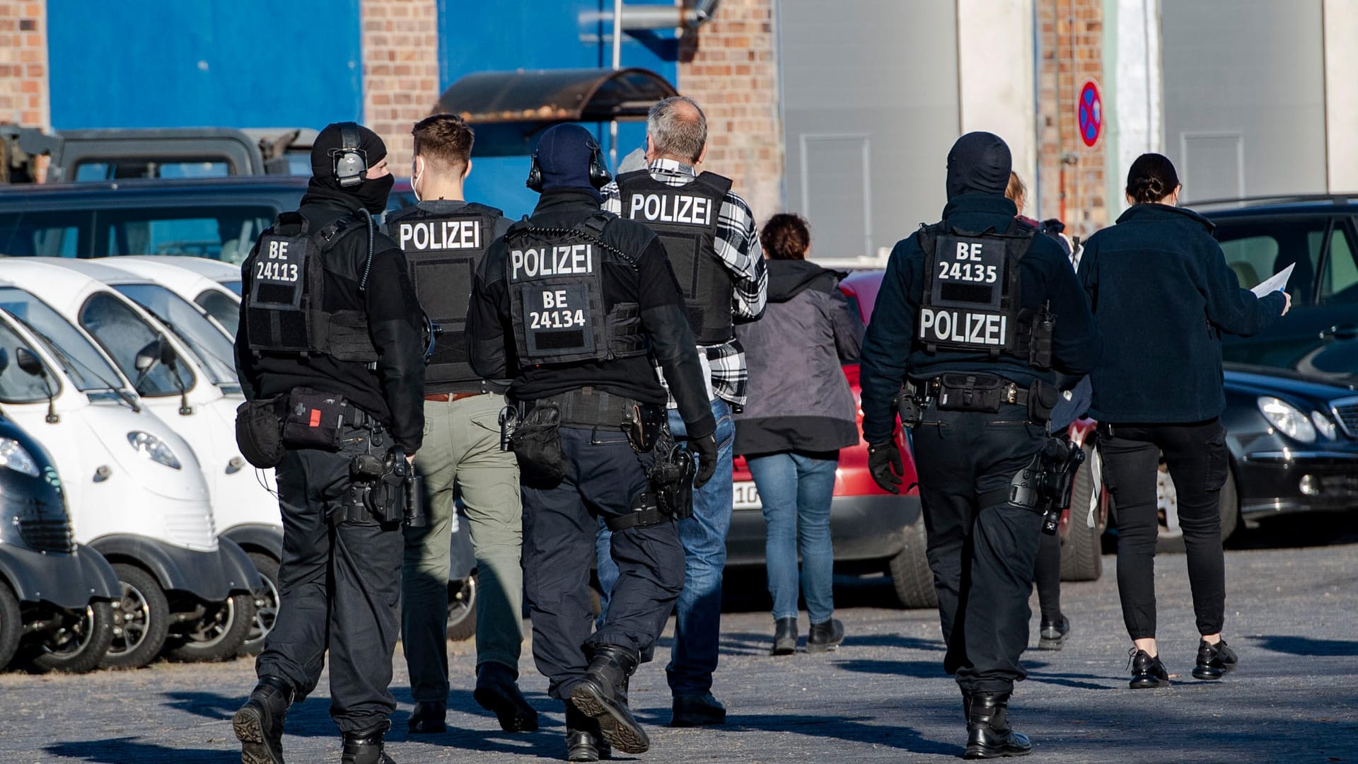 Polizeibeamte gehen über einen Hof eines Gewerbegebietes in Weißensee: Mehrere Objekte in Berlin wurden durchsucht.