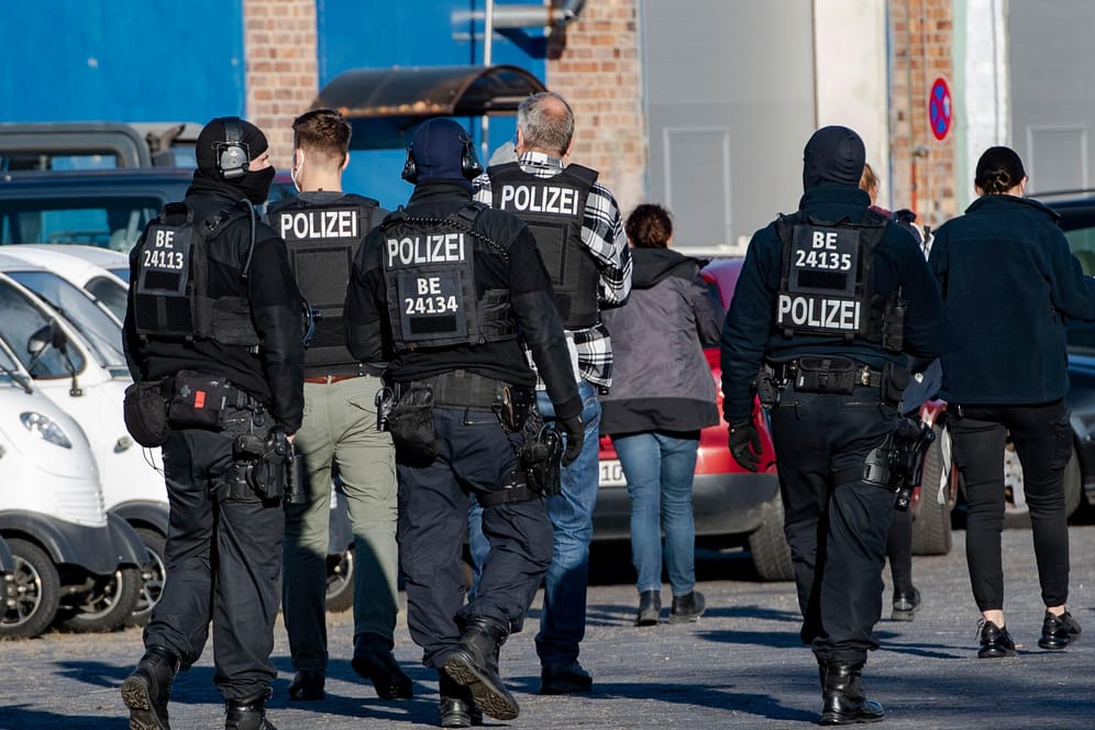 Polizeibeamte gehen über einen Hof eines Gewerbegebietes in Weißensee: Mehrere Objekte in Berlin wurden durchsucht.
