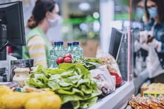 Eine Kundin an der Supermarktkasse (Symbolbild): Die hohe Inflation merken viele Verbraucher bereits beim Einkaufen an gestiegenen Preisen.