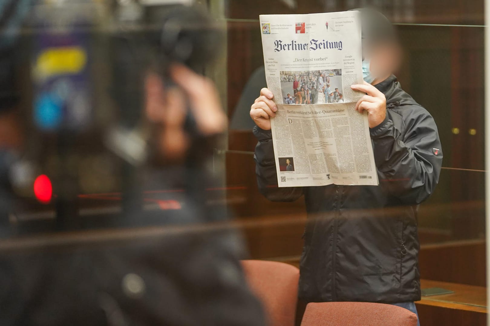 Der Angeklagte hält sich eine Zeitung vor sein Gesicht, während er zum Prozessbeginn in den Berliner Gerichtssaal kommt: Der 56-Jährige wurde zu einer Bewährungsstrafe verurteilt.