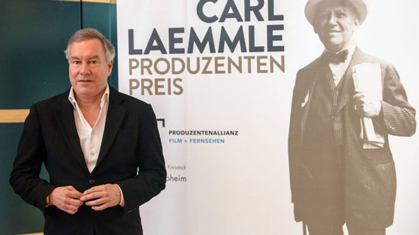 Nico Hofmann neben einem Porträt von Carl Laemmle.
