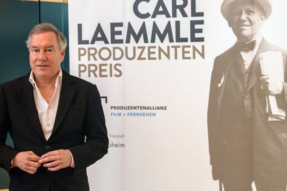 Nico Hofmann neben einem Porträt von Carl Laemmle.