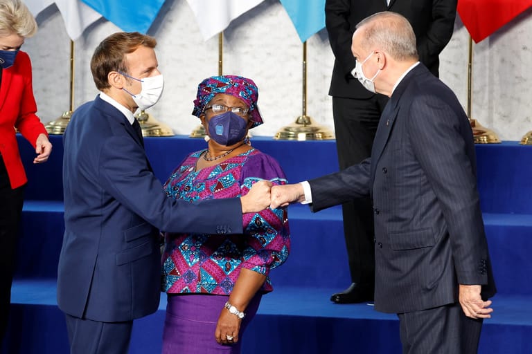 Emmanuel Macron und Recep Tayyip Erdoğan geben sich die Corona-Faust: Ngozi Okonjo-Iweala, die Chefin der Welthandelsorganisation (WTO), beäugt den türkischen Staatschef indes kritisch.