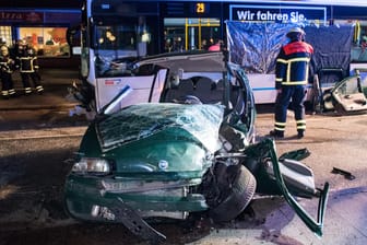 Ein zertrümmertes Auto steht vor einem Bus in Hamburg: Bei zwei Unfällen mit Bussen gab es viele Verletzte.