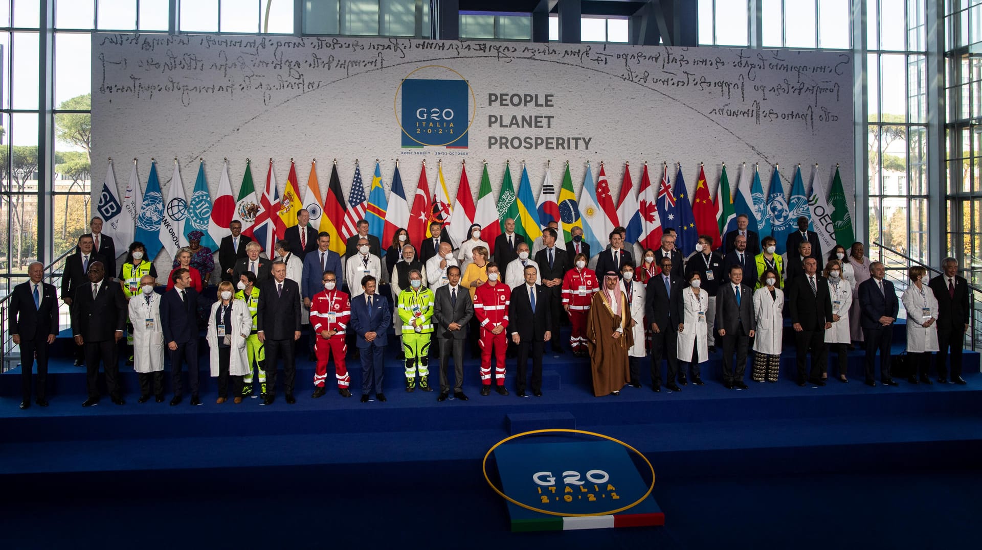 Ein besonderes G20-Familienfoto: Medizinisches Personal steht zusammen mit den Staats- und Regierungschefs im Konferenzzentrum La Nuvola.