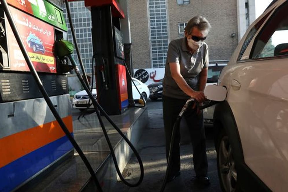 Ein Mann betankt sein Auto an einer Tankstelle.