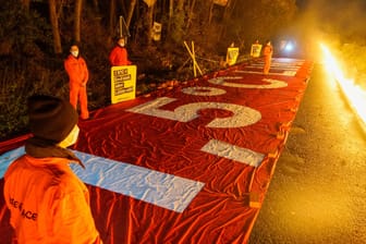 Protestanten in Lützerath: Mit einem roten Banner und einer "Feuerlinie" demonstriert Greenpeace vor einem Bauernhof in Lützerath gegen den Braunkohletagebau Garzweiler.