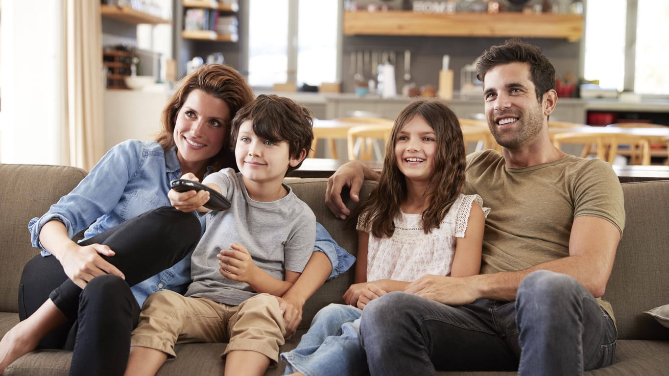 Eine Familie sitzt vor dem Fernseher (Symbolbild): Die Mediennutzung der Deutschen ist auf einen Rekordwert gestiegen.