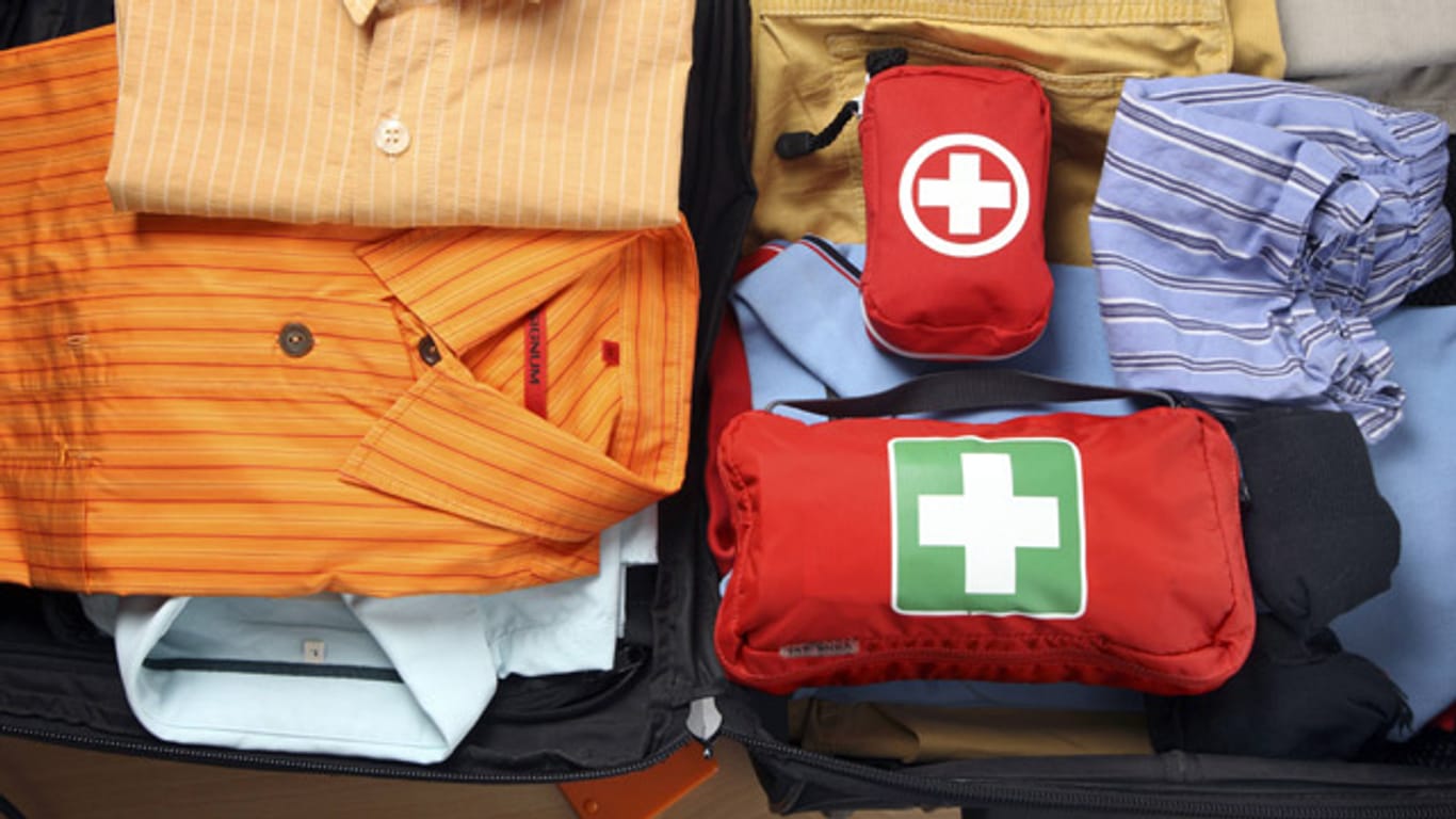 Ein offener Koffer mit Gepäck: Ins Handgepäck gehören wichtige Dokumente, Wertgegenstände sowie ein Notfallset.