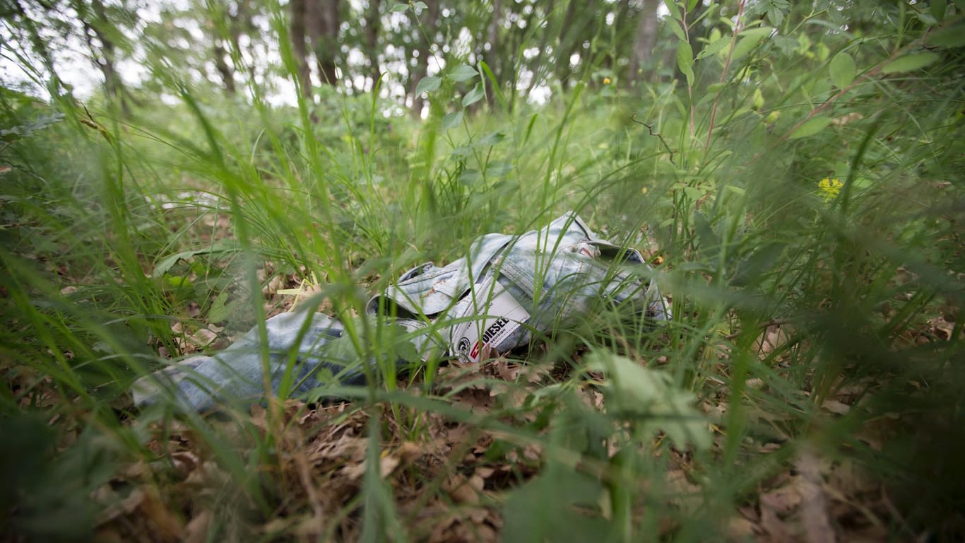 Im Gras haben Flüchtlinge ihre zerschlissene Kleidung zurückgelassen so wie diese alte "Diesel“-Jeans.