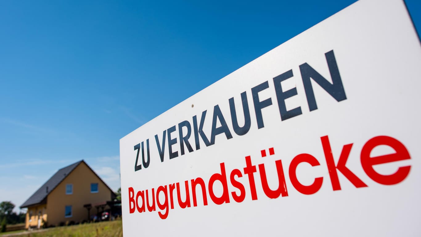 Ein Schild mit der Aufschrift "Zu verkaufen - Baugrundstücke" steht auf einem Grundstück im brandenburgischen Petersdorf.