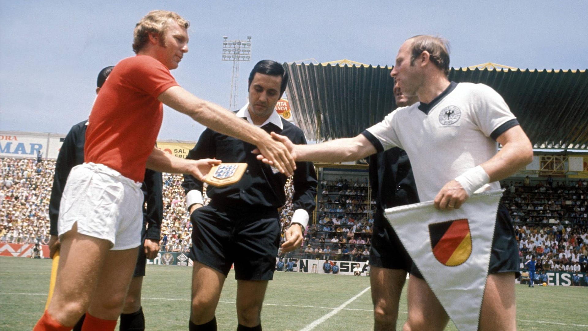 Uwe Seeler und Bobby Moore tauschen die Wimpel aus.