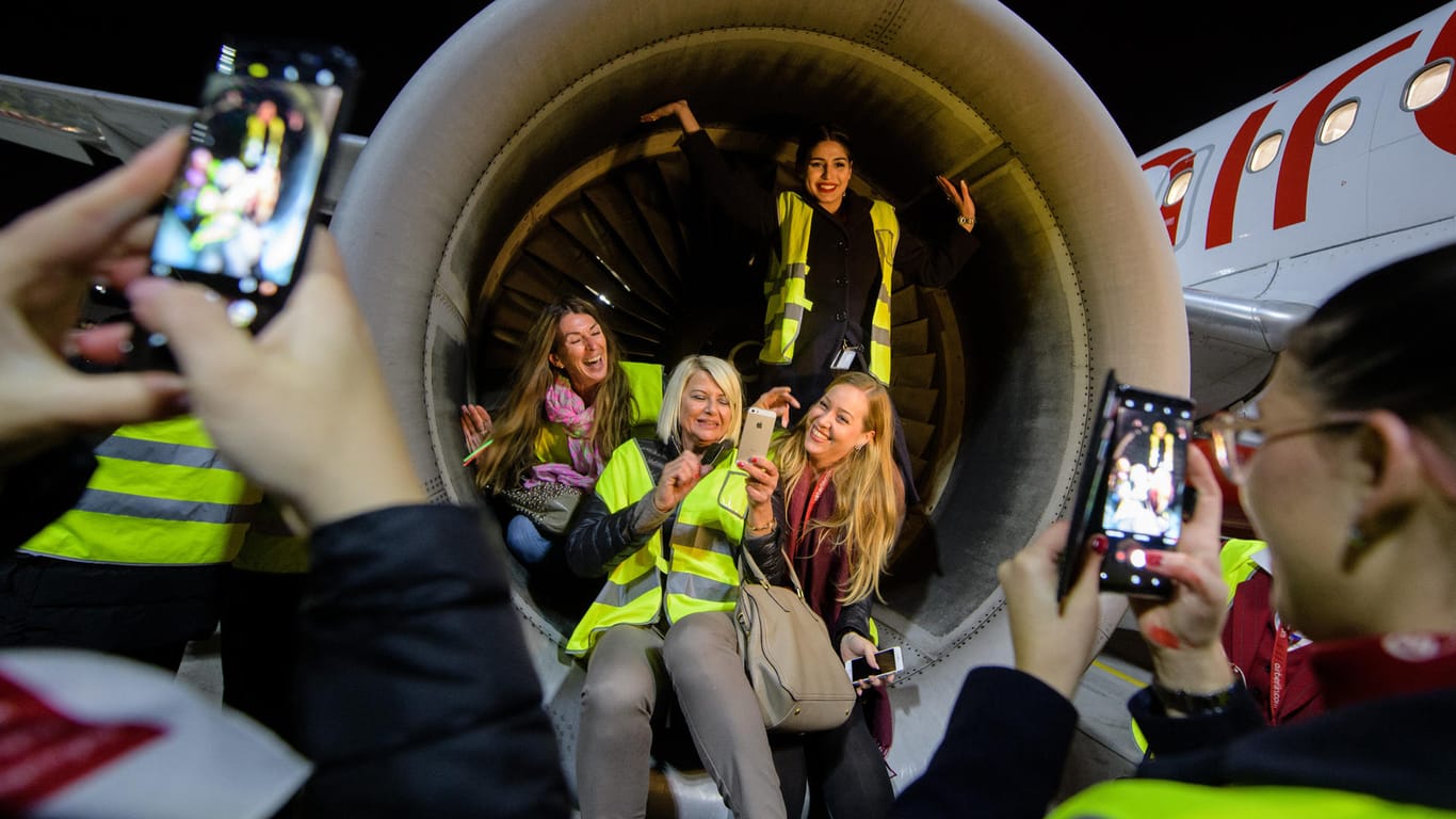 Crewmitglieder der Air Berlin lassen sich auf dem Flughafen in München in der Turbine der letzten Maschine von Air Berlin fotografieren.