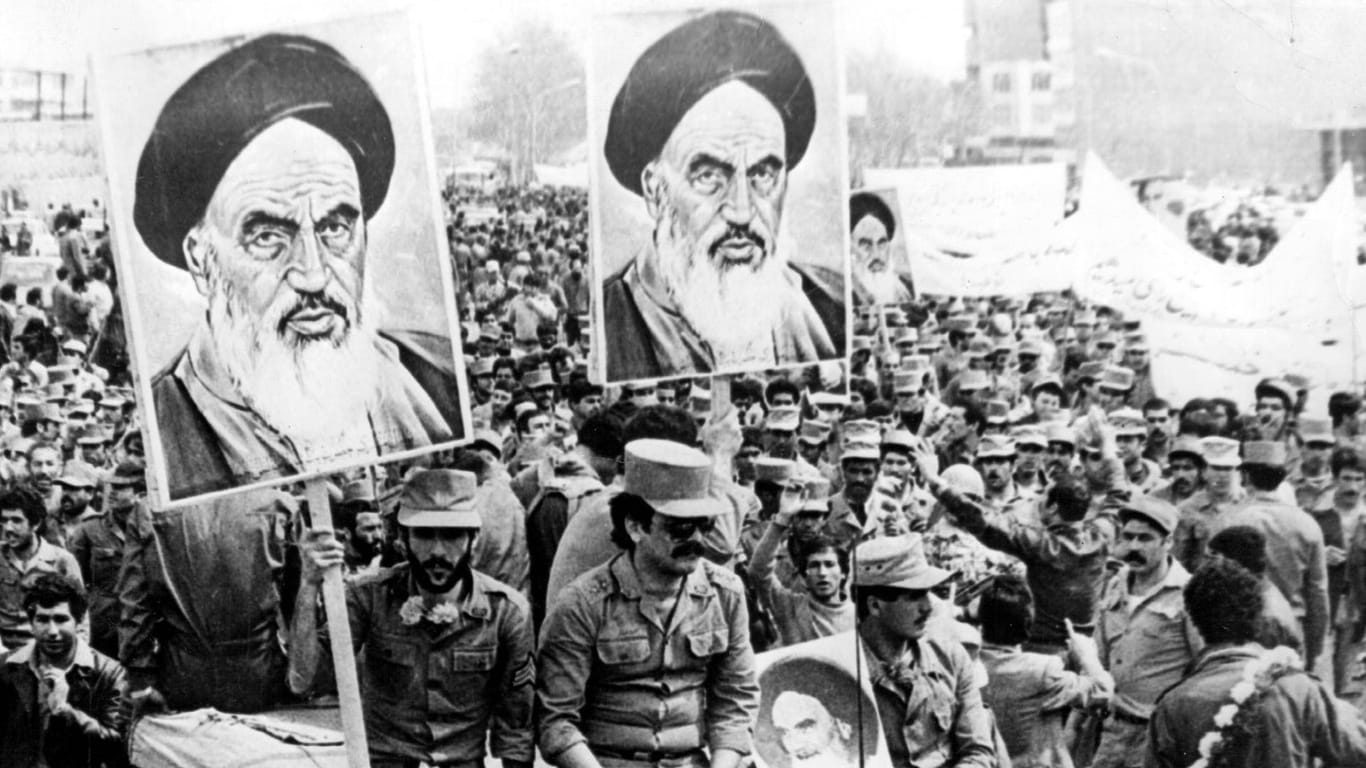 Demonstrationen gegen den Shah in Teheran 1978: Menschen halten Plakate mit Konterfei Ayatollah Khomeinis hoch.