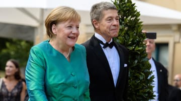 Angela Merkel mit ihrem Mann Joachim Sauer: Sie trug ein grün schimmerndes Kostüm.
