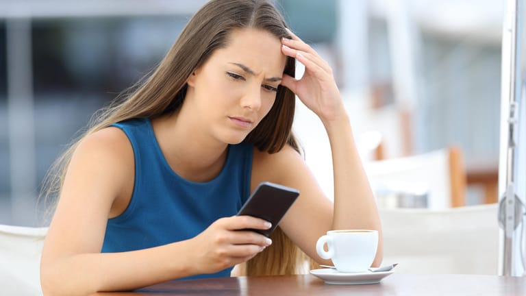 Frau mit Smartphone: Mit einem Trick können Sie den Besitzer einer Handynummer kostenlos herausfinden.