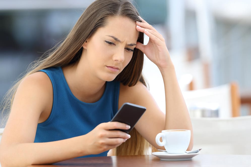 Frau mit Smartphone: Mit einem Trick können Sie den Besitzer einer Handynummer kostenlos herausfinden.