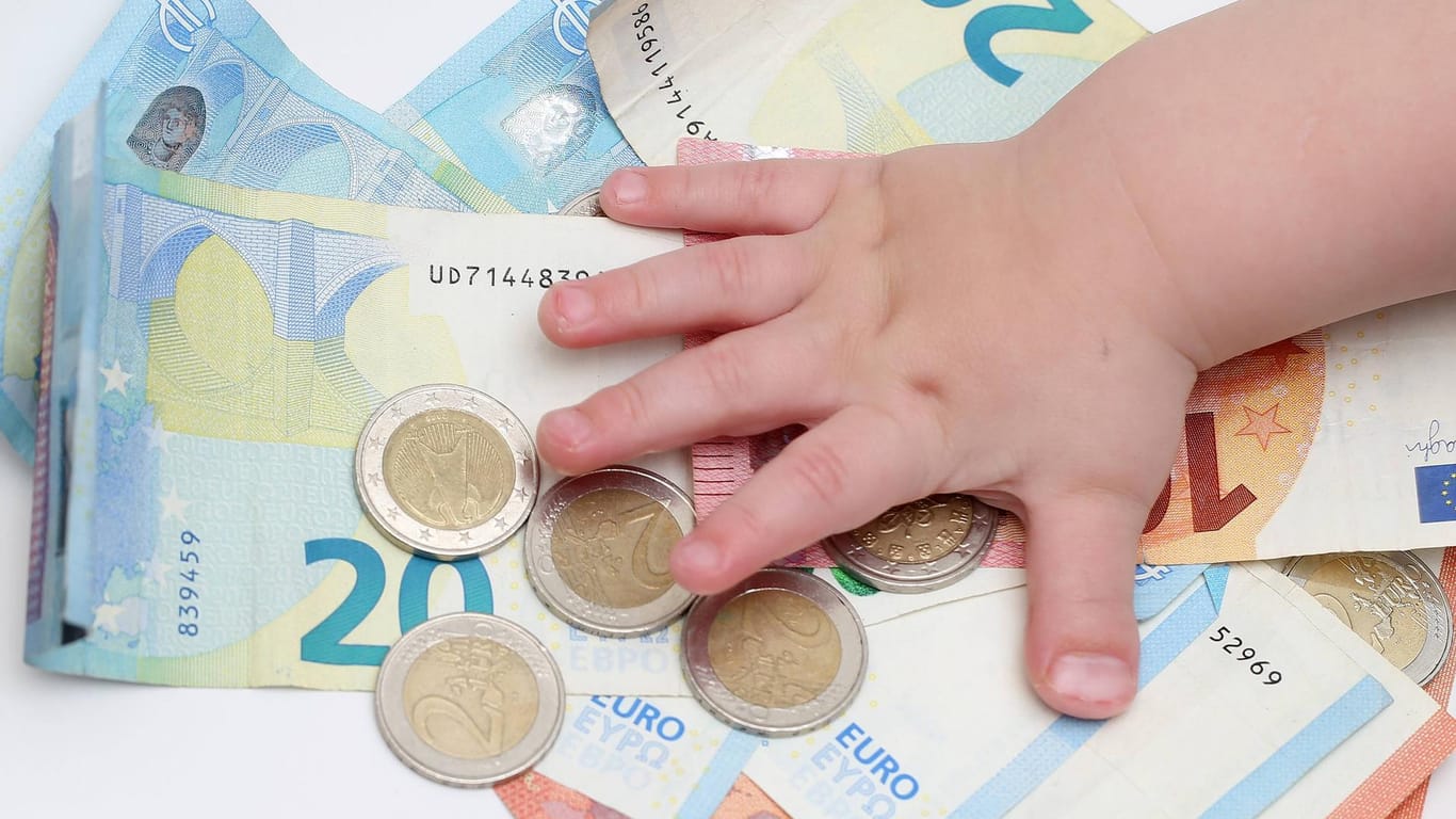 Geld und Kinderhand: Sowohl Kindergeld als auch Kinderfreibetrag sind also steuerbegünstigt. (Symbolbild)