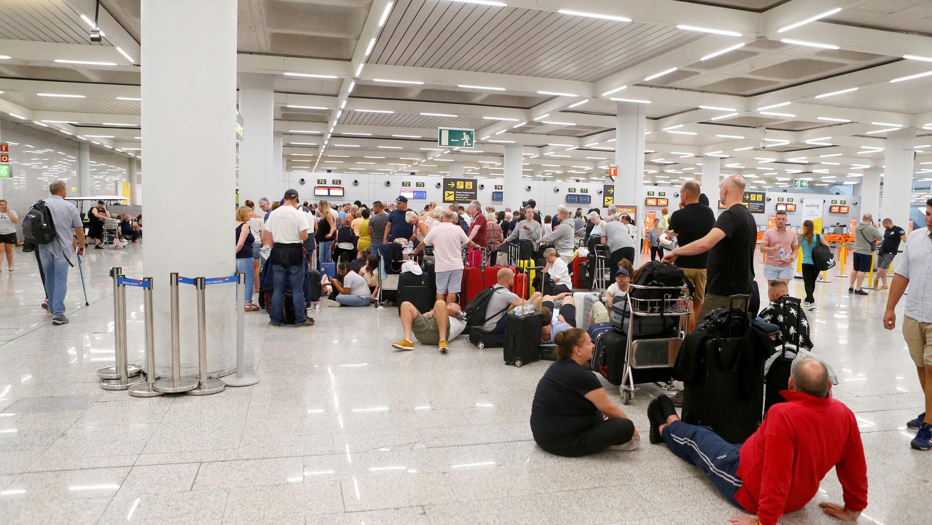 Passengers are seen at Thomas Cook check-in points at Mallorca Airport after the world's oldest travel firm collapsed, in Palma de Mallorca