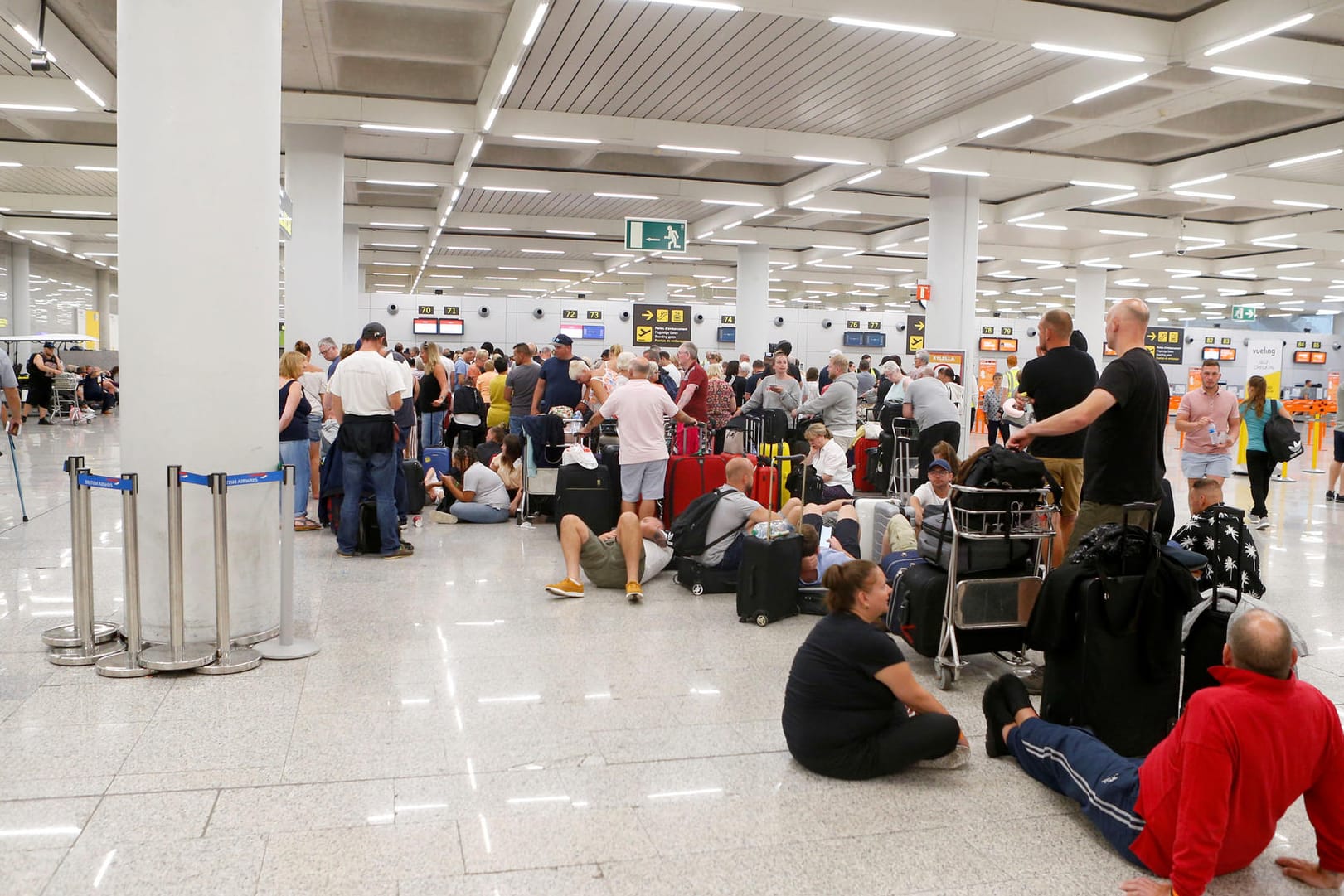 Passengers are seen at Thomas Cook check-in points at Mallorca Airport after the world's oldest travel firm collapsed, in Palma de Mallorca