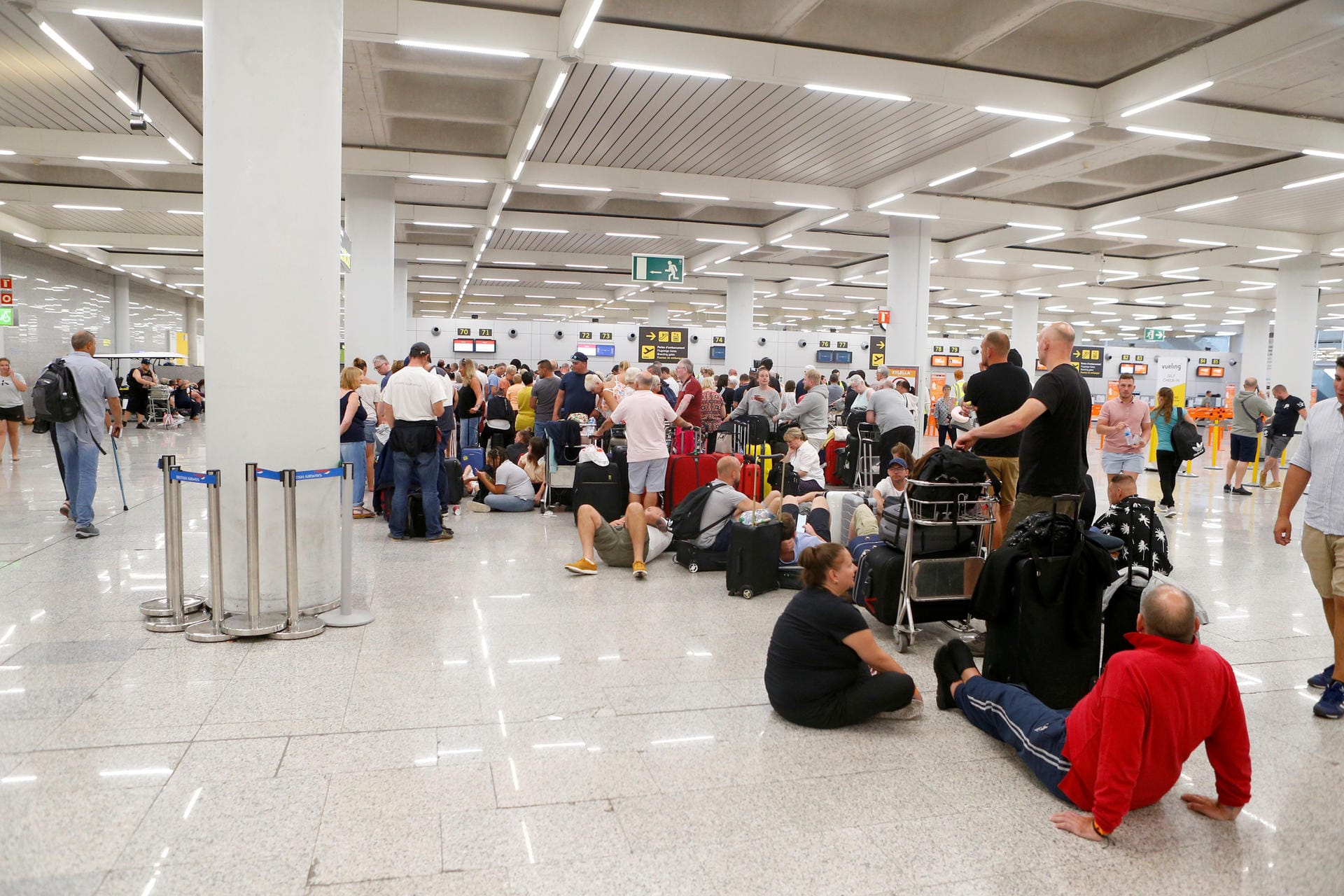 Passengers are seen at Thomas Cook check-in points at Mallorca Airport after the world's oldest travel firm collapsed, in Palma de Mallorca