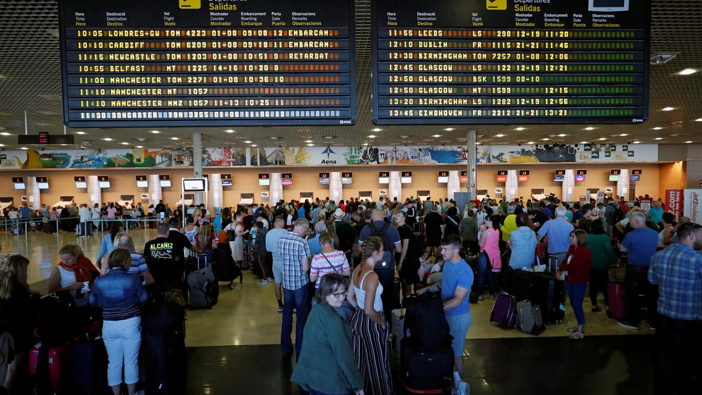 Thomas Cook passengers queue in front of check-in desks at Reus airport