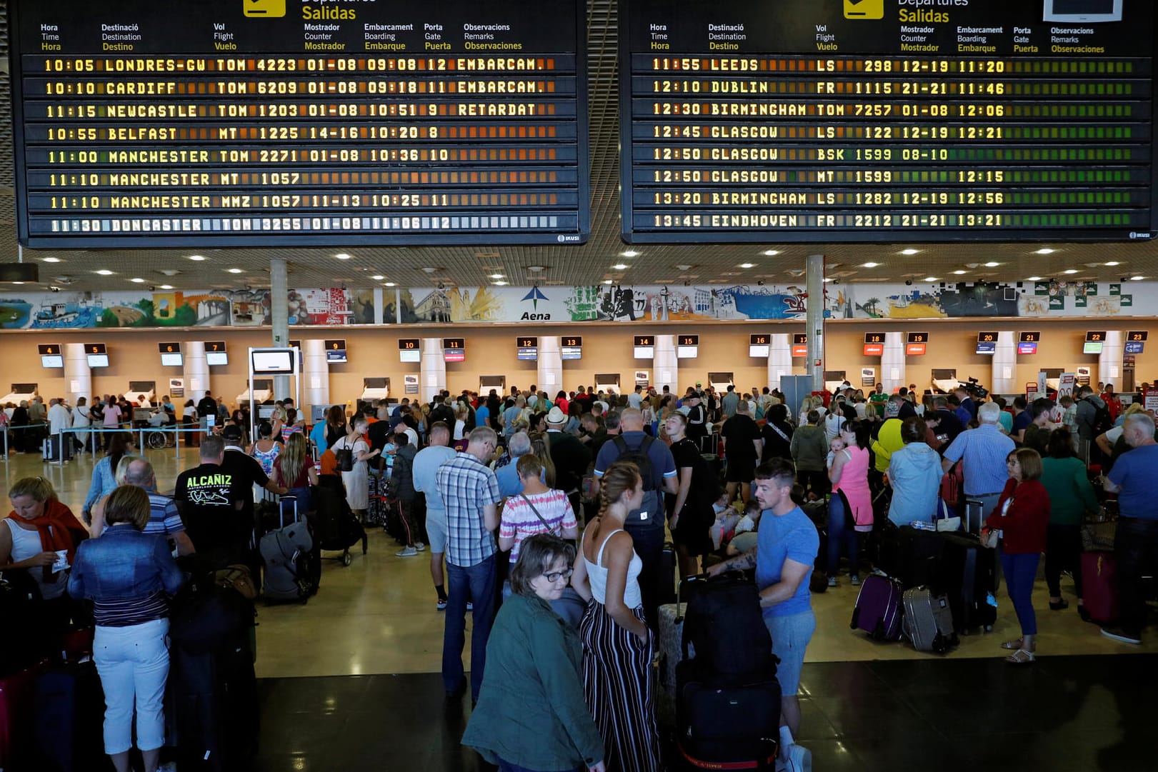 Thomas Cook passengers queue in front of check-in desks at Reus airport