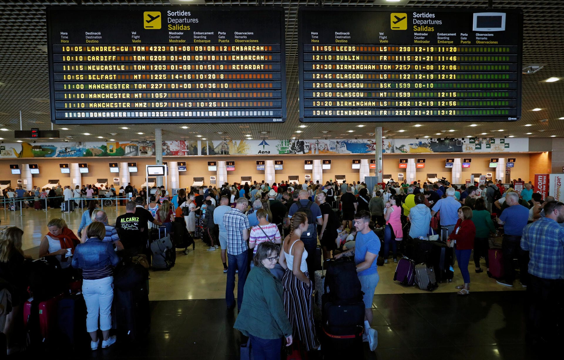 Thomas Cook passengers queue in front of check-in desks at Reus airport