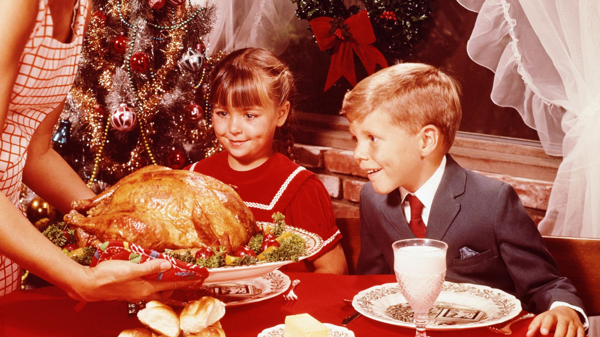 Kinder schauen erwartungsvoll auf das Weihnachtsessen