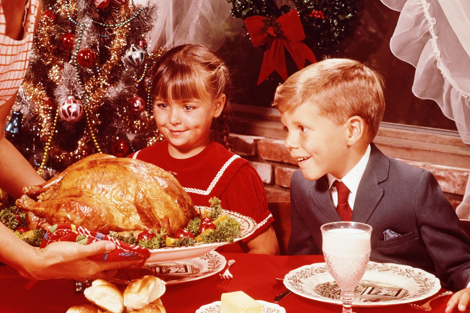 Kinder schauen erwartungsvoll auf das Weihnachtsessen