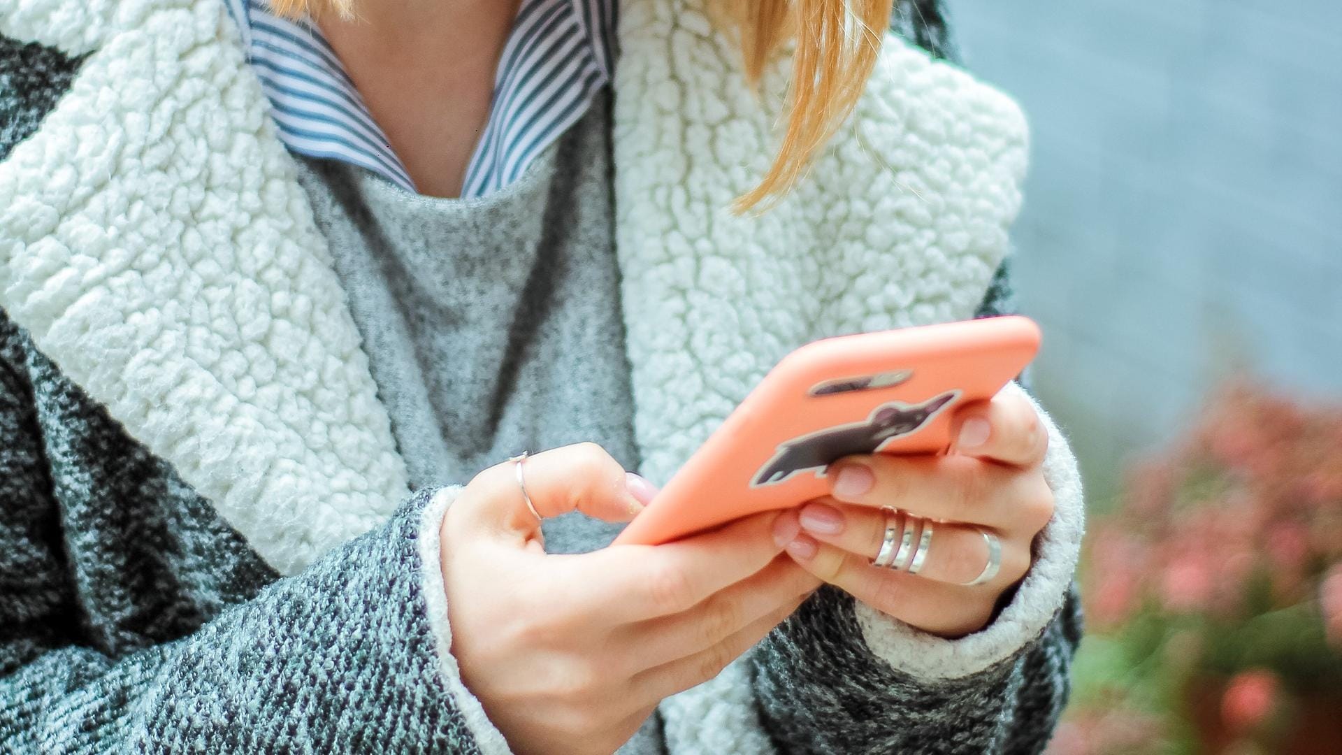 Eine Frau mit einem Handy: Wie kommt man mit einer fremden Person ins Gespräch?