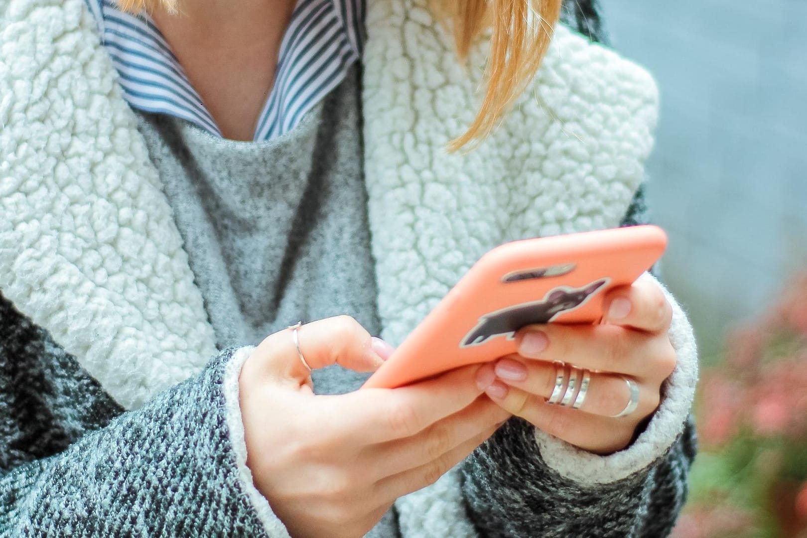 Eine Frau mit einem Handy: Wie kommt man mit einer fremden Person ins Gespräch?